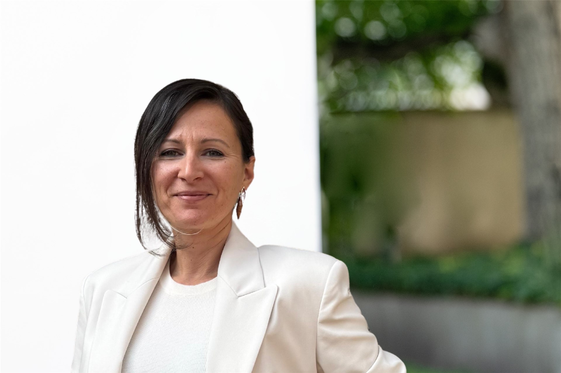 Frau mit weißer Bluse vor weißen und grünem Hintergrund